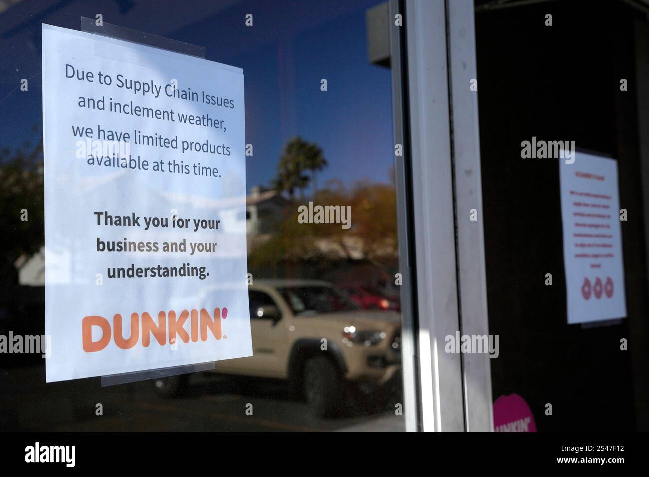 Signs on the doors of a Dunkin' Donuts restaurant explains that