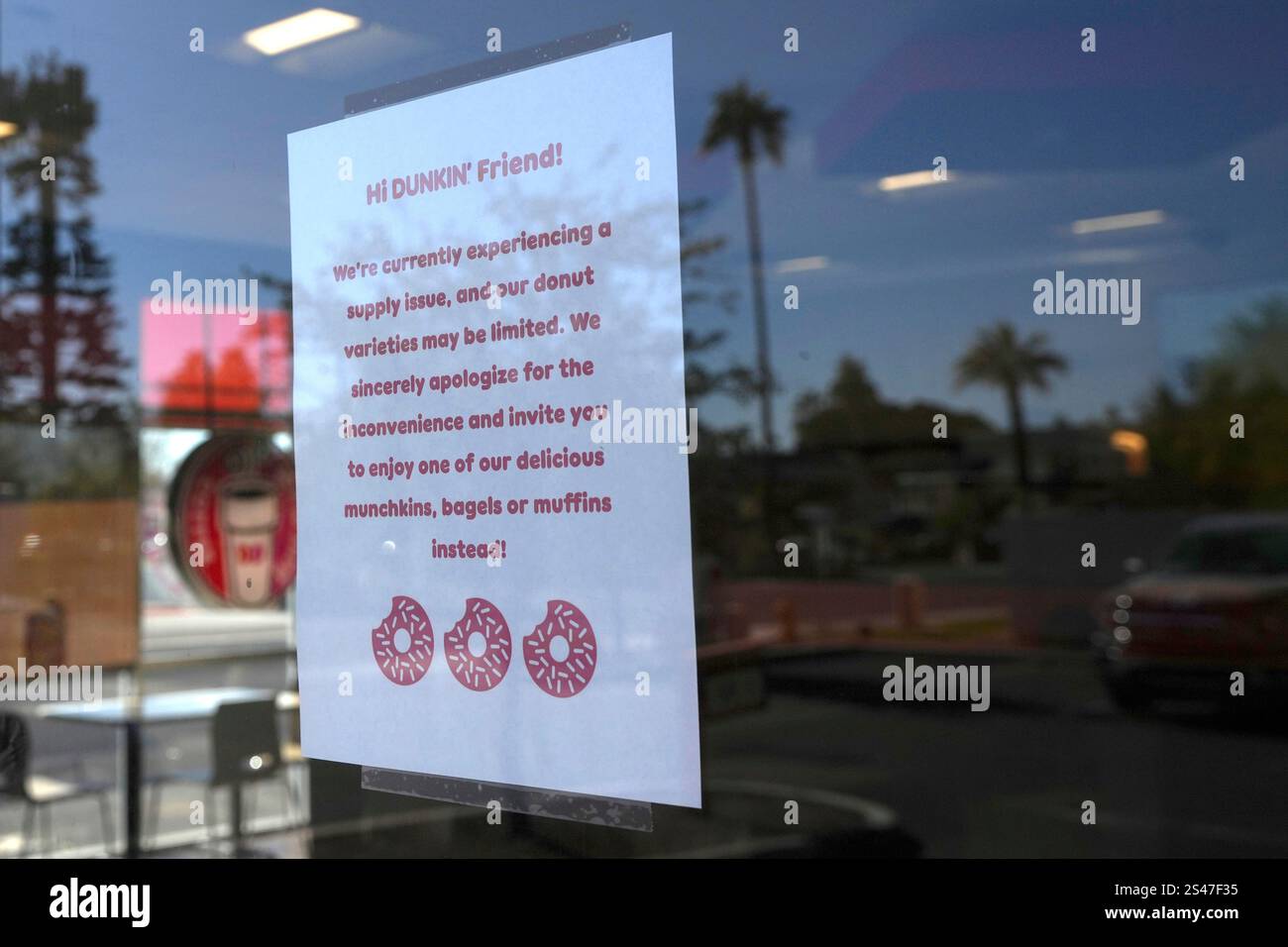 A sign on the door of a Dunkin' Donuts restaurant explains that