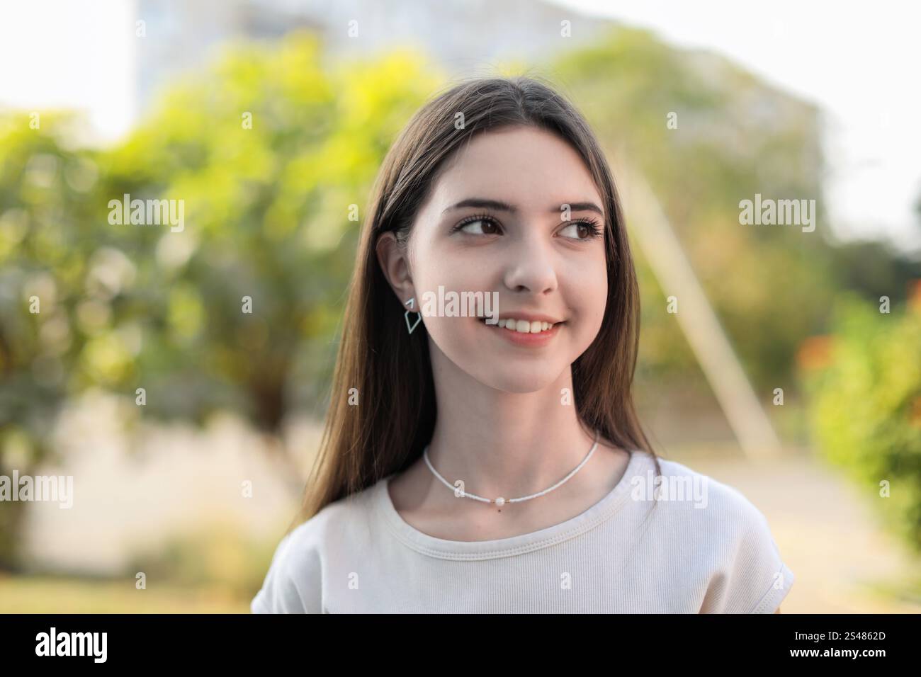Portrait of smiling teenage girl on city street Stock Photo - Alamy