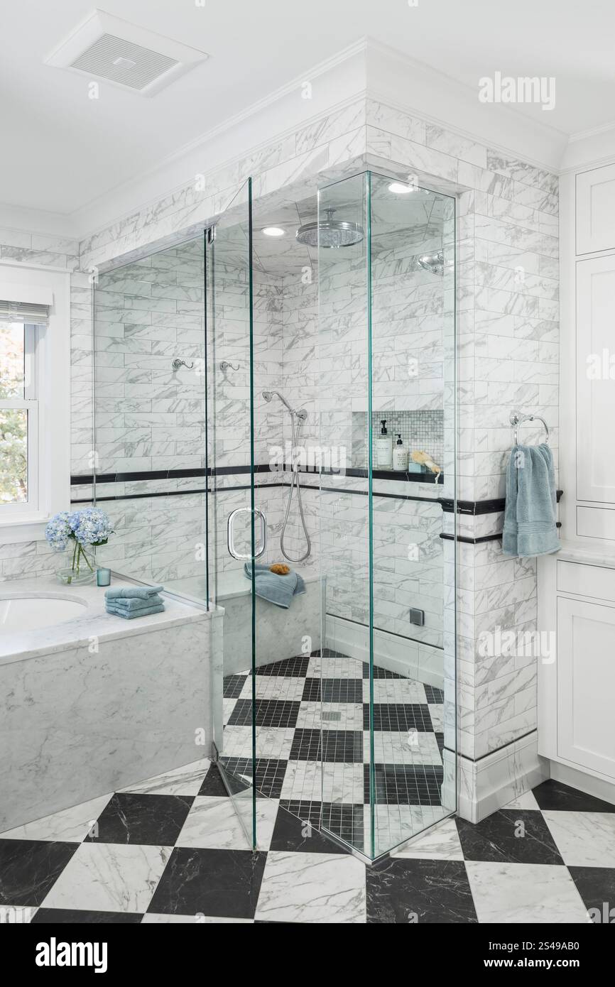 Walk-in shower with marble tile walls and black and white checkerboard ...