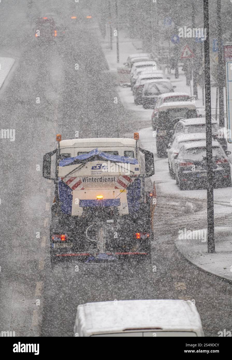 Winter weather, heavy snowfall, city centre traffic, winter service vehicle from Entsorgungsbetriebe Essen in action on Alfredstrasse, B224, gritting Stock Photo