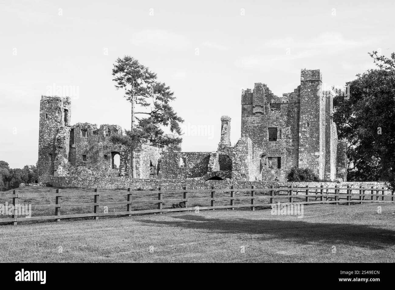 A castle with a fence in front of it. The castle is old and has a lot of stone Stock Photo