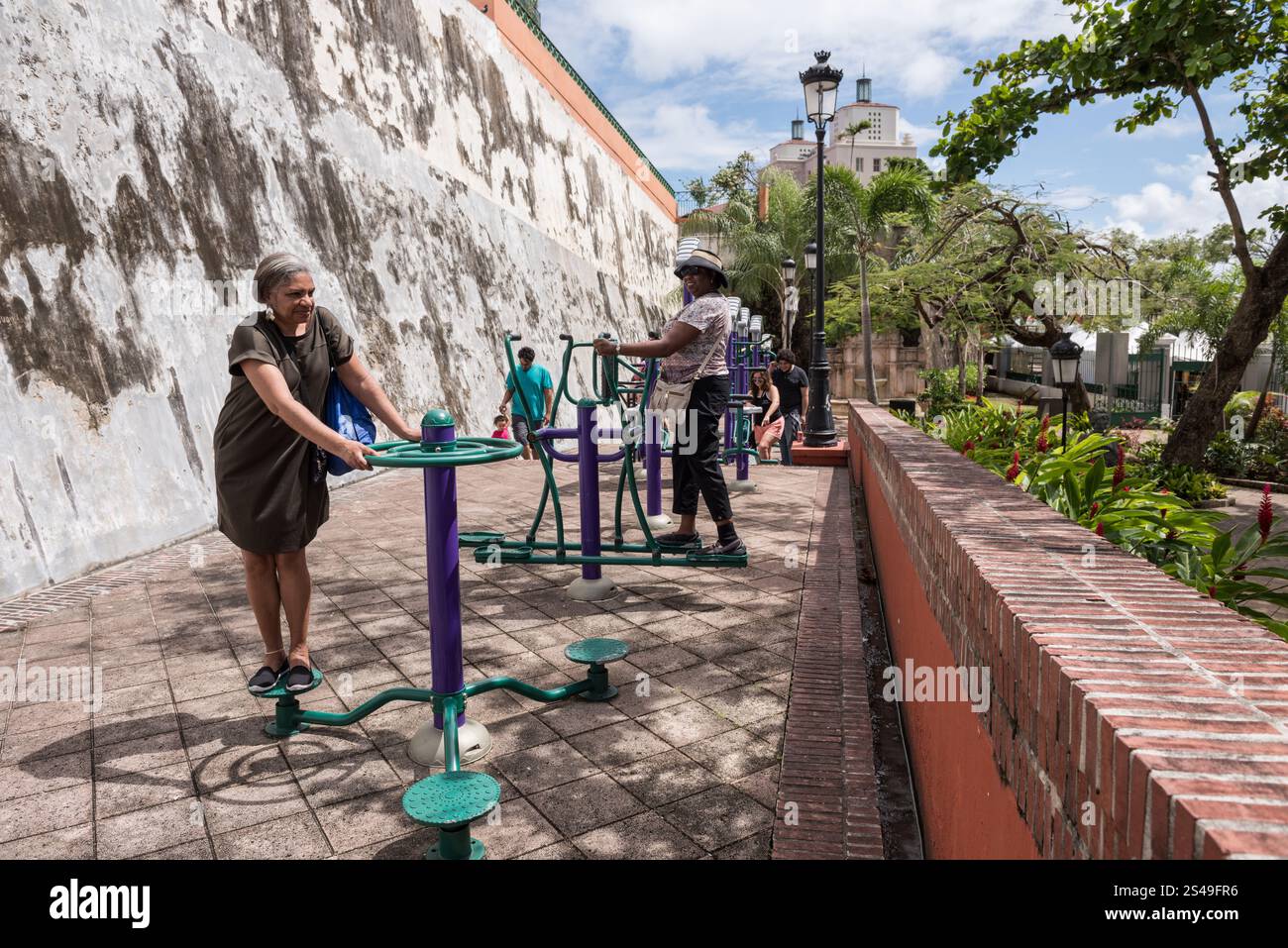 San Juan, Puerto Rico - February 25, 2018: Women using TropiFit fitness stations in Jardin de La Princessa (Princess Garden) in Old San Juan. Stock Photo