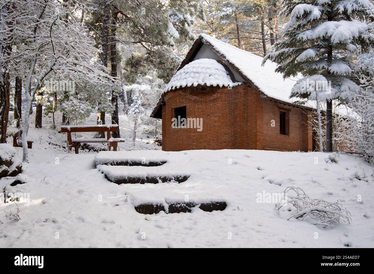Small brick christian chapel covered by snow in a forest during winter. Panagia plataniotissa Troodos, Cyprus Stock Photo