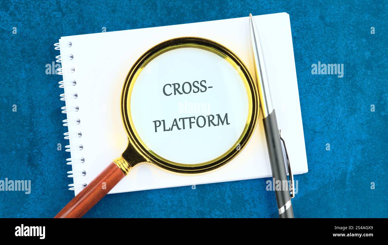 Context Marketing concept. Text CROSS-PLATFORM in a clean notebook through a magnifying glass. Stock Photo