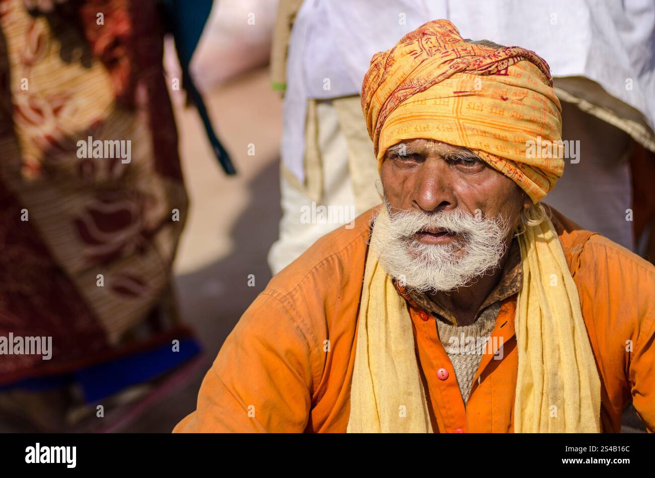 Elderly man in traditional attire at a vibrant cultural festival in ...
