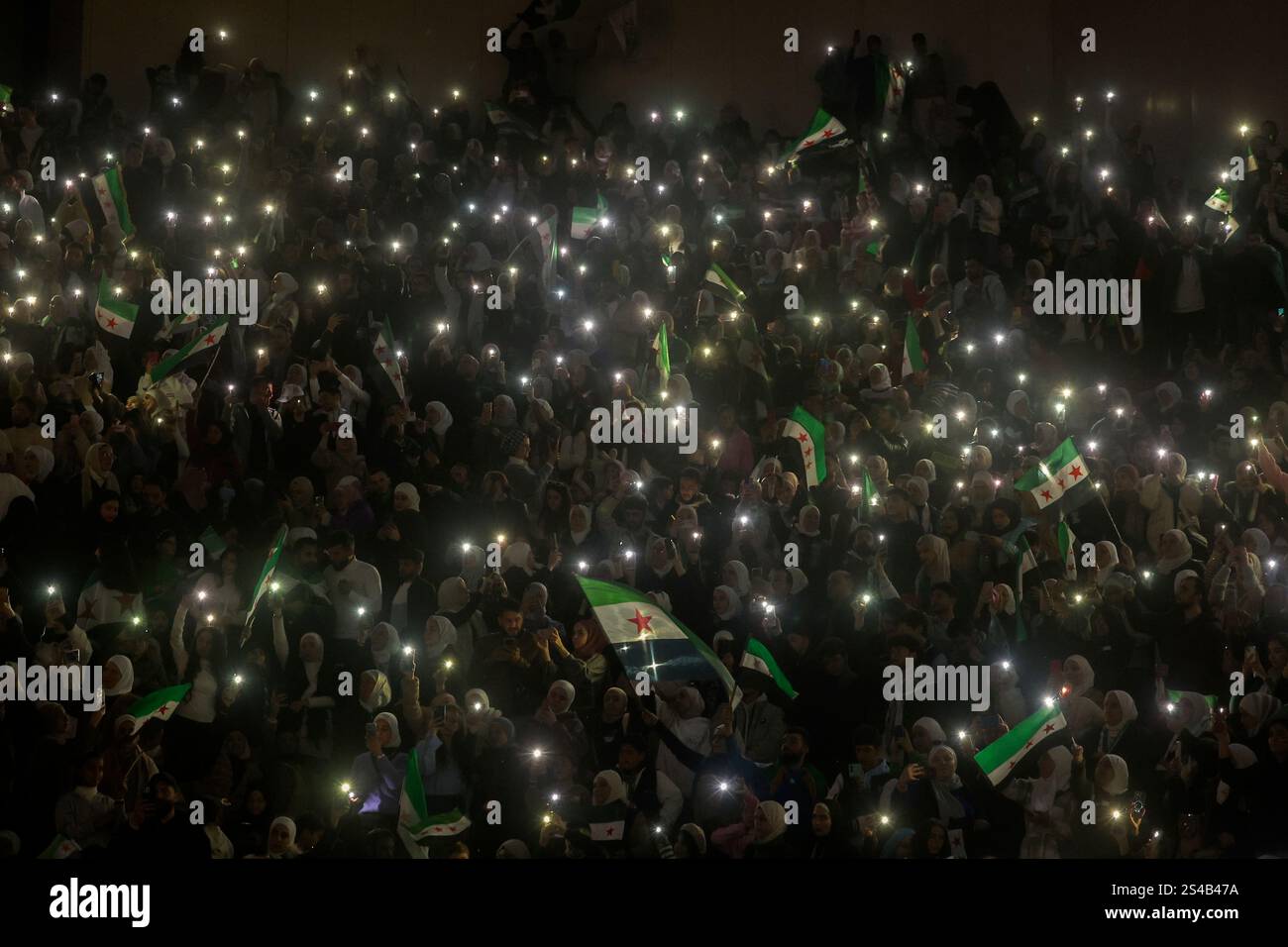 Syrians sing and wave post-Assad flags during a concert by the recently ...