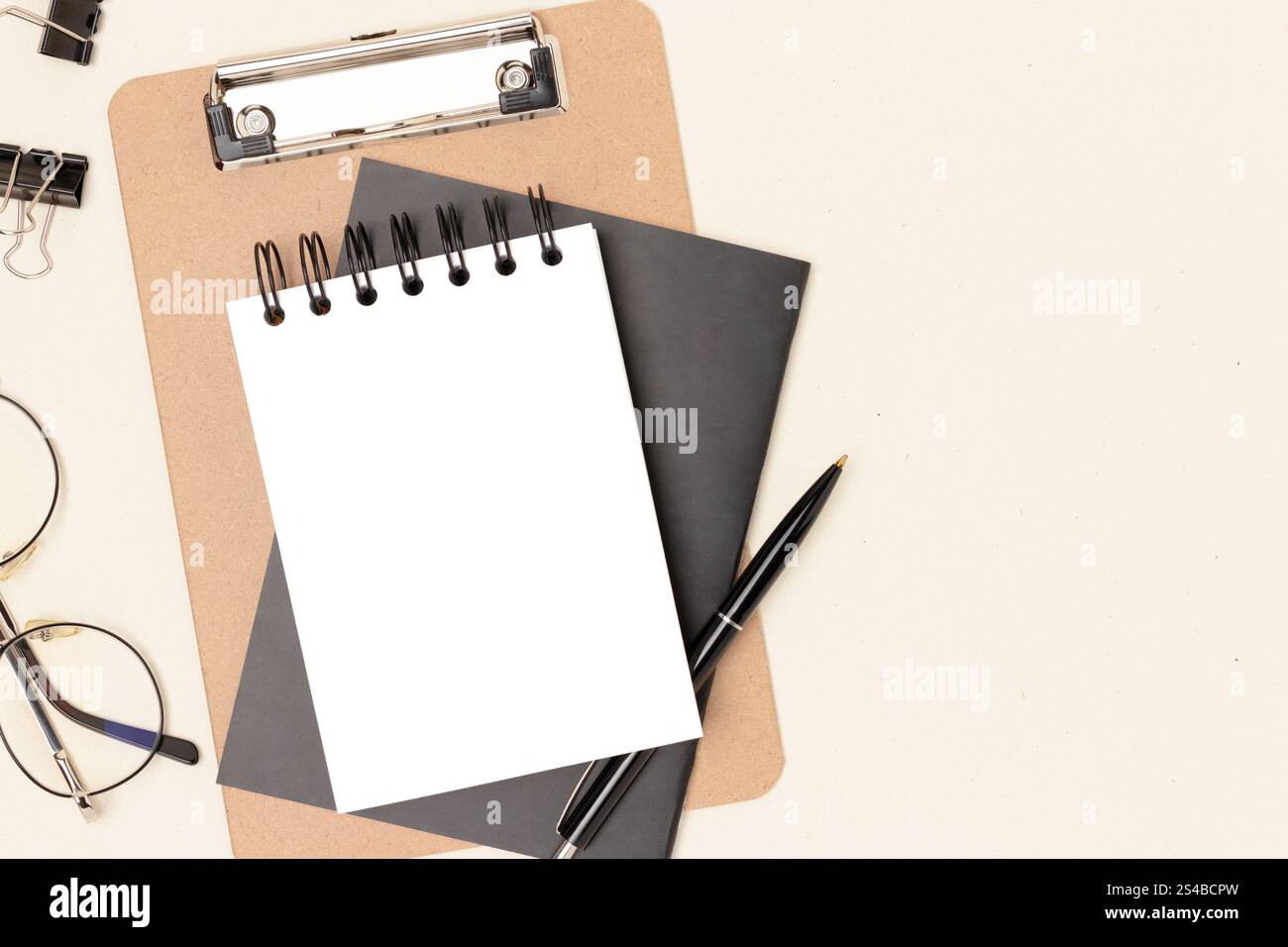 Workspace with clean notepad mockup, eyeglasses and stationery on a ...