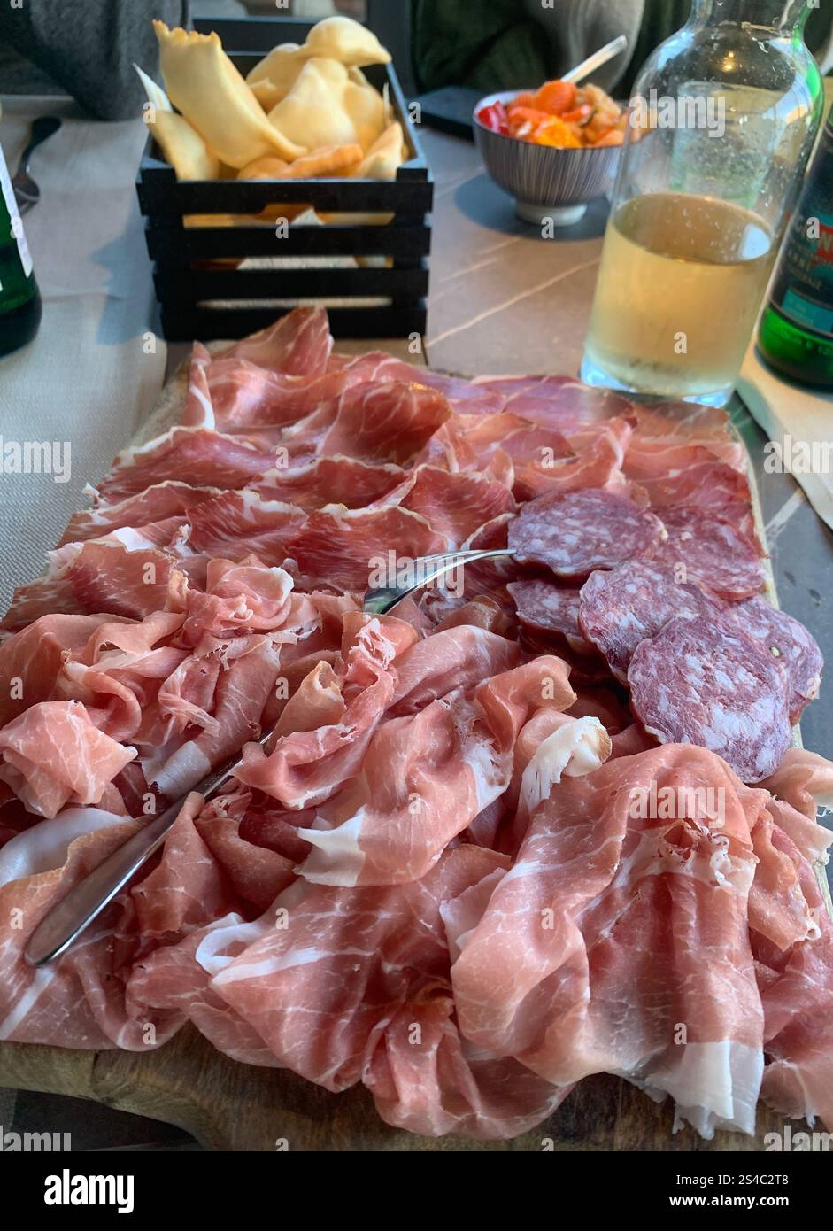 A platter of sliced cured meats served as a starter in an Italian restaurant - Smartphone Captured Stock Image