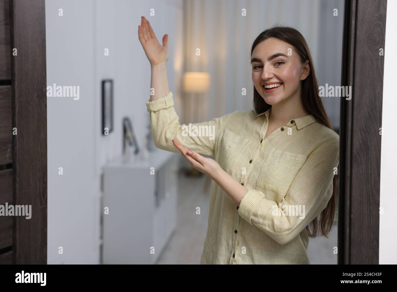 Happy woman welcoming guests to her house Stock Photo - Alamy