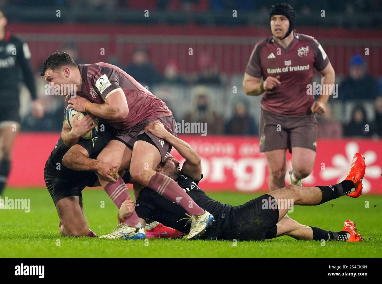 Munster's Tom Farrell is tackled by Saracens' Ben Earl (left) and Alex ...