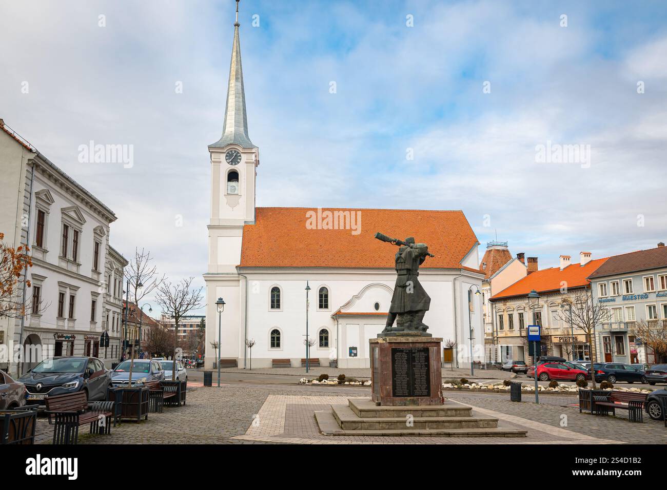 Reformed church in the center of Odorheiu Secuiesc (Hungarian: Székelyudvarhely) in Transylvania, Romania. In the foreground the Vasszékely monument. Stock Photo