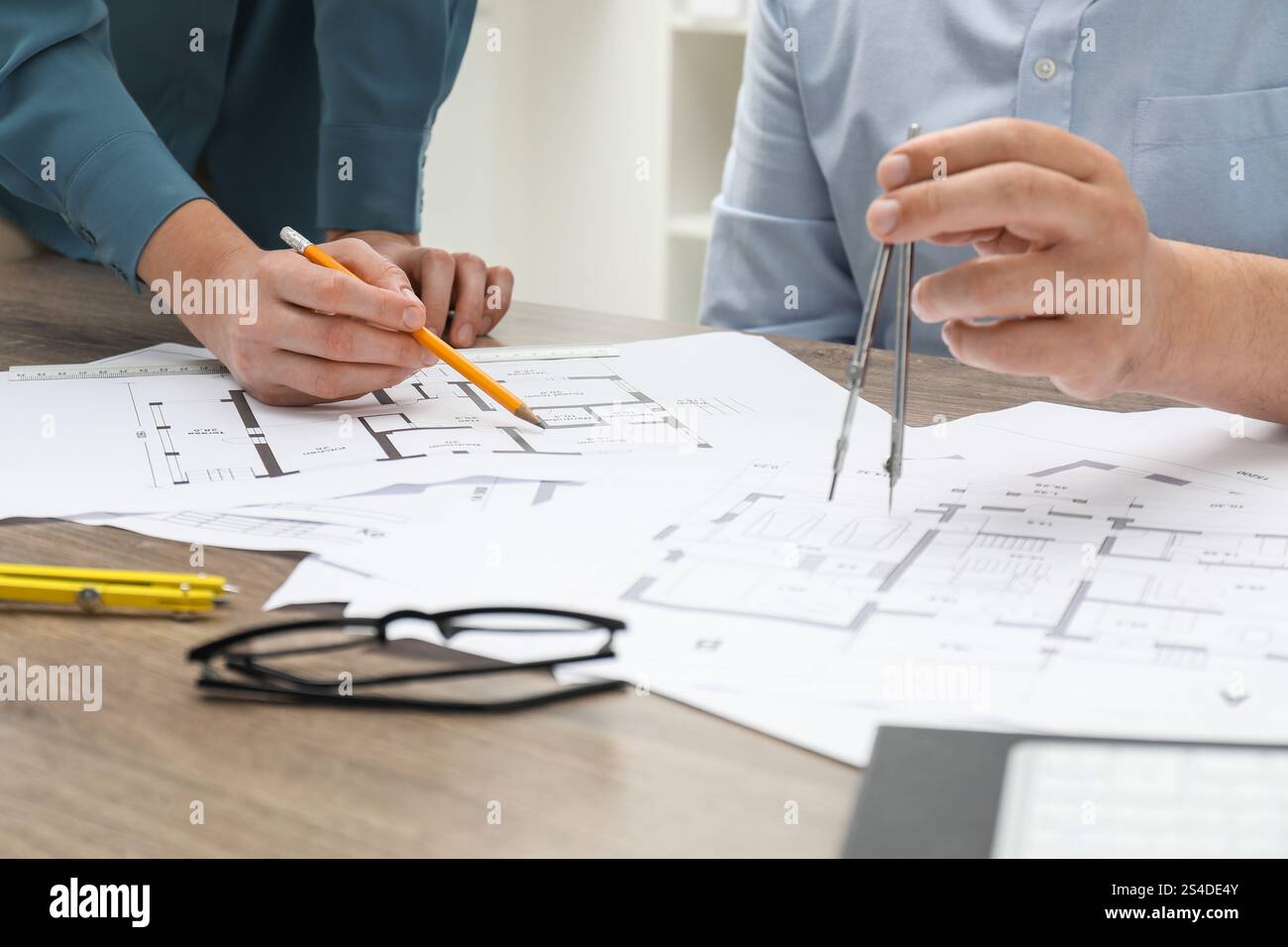 Architects working with project, closeup. Different technical drawings on wooden table Stock Photo