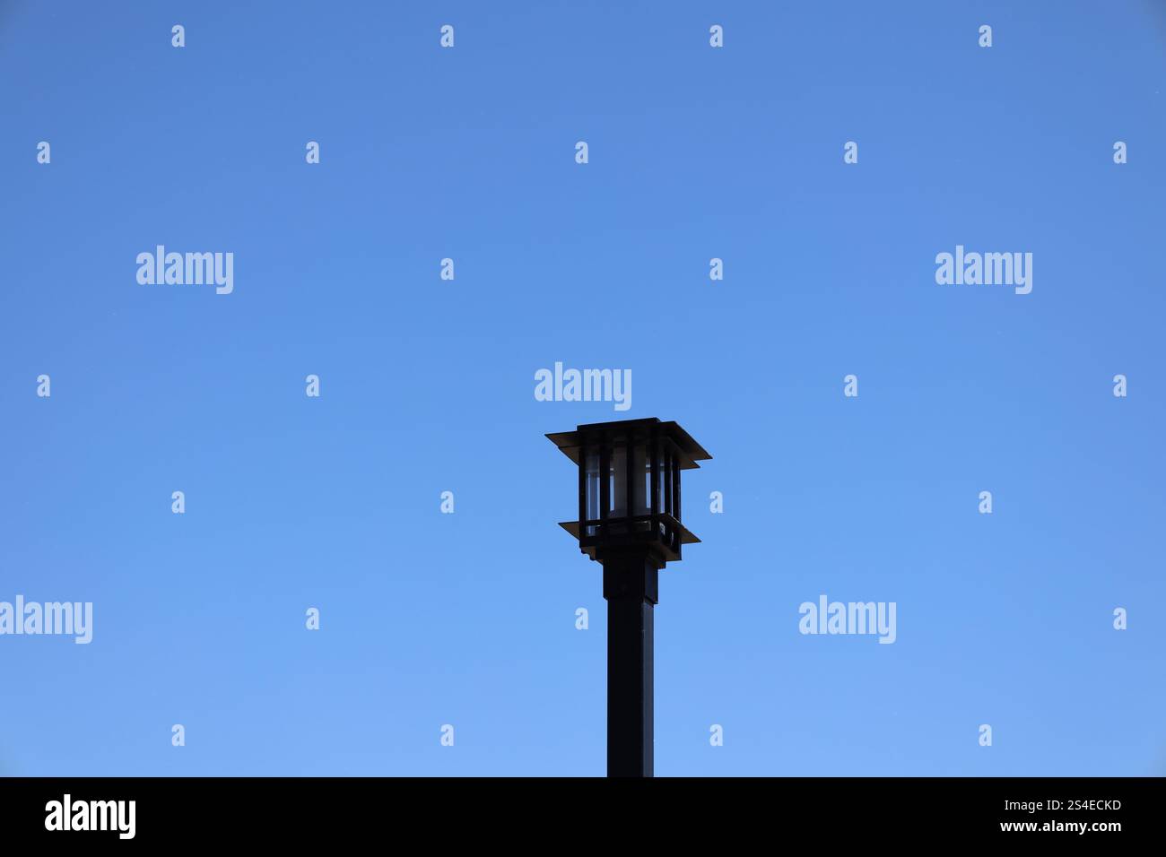 black iron lamp post against a deep blue cloudless clear sky Stock Photo