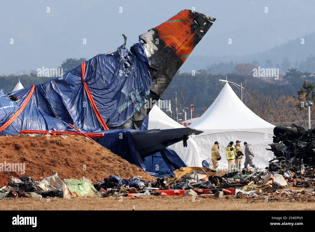 12th Jan, 2025. Site of Jeju Air crash Firefighters inspect the site of ...