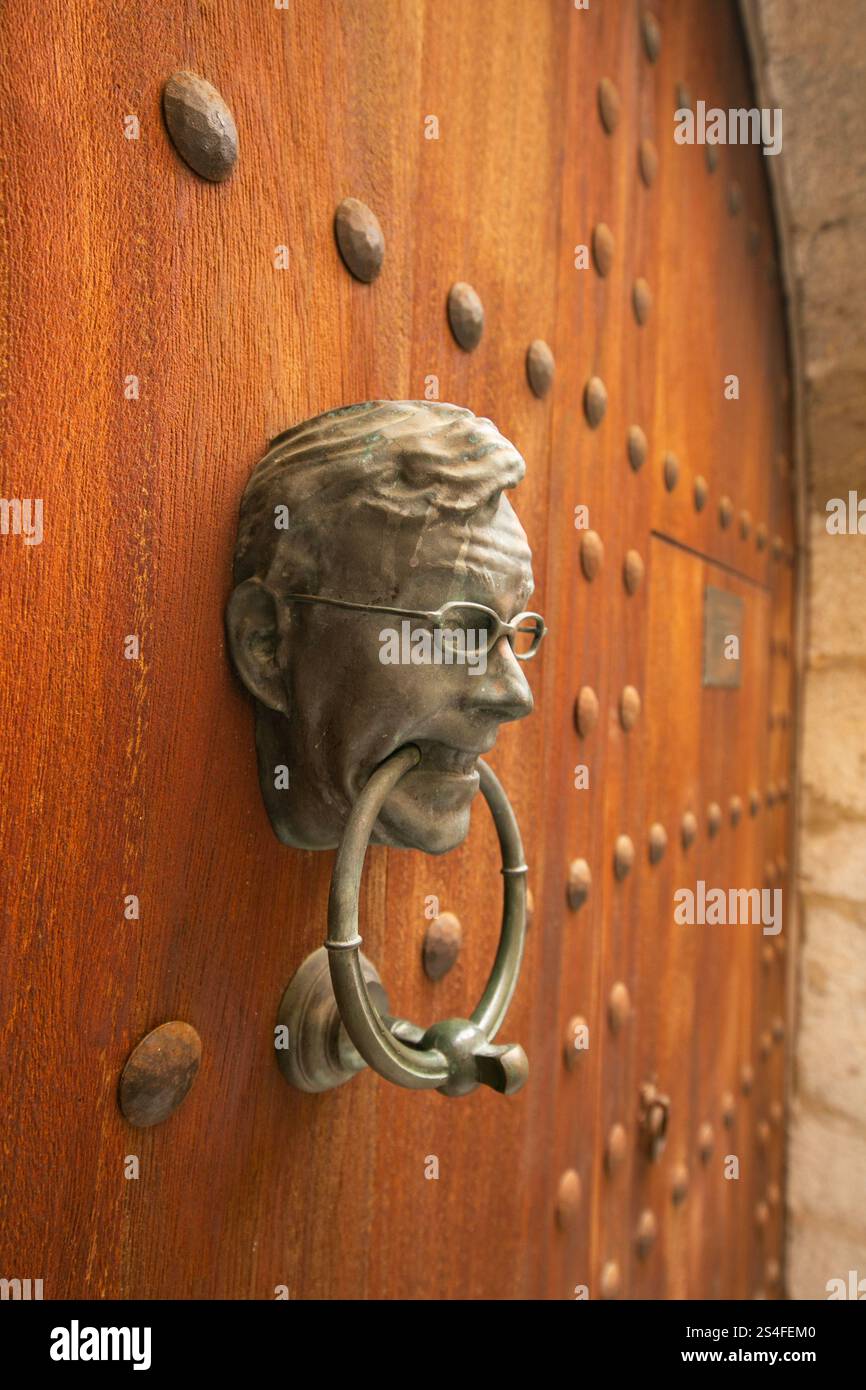 Knob of an old wooden door with a man's face carved in iron. Stock Photo