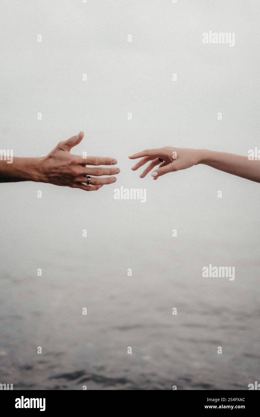 two hands reaching out towards each other Stock Photo