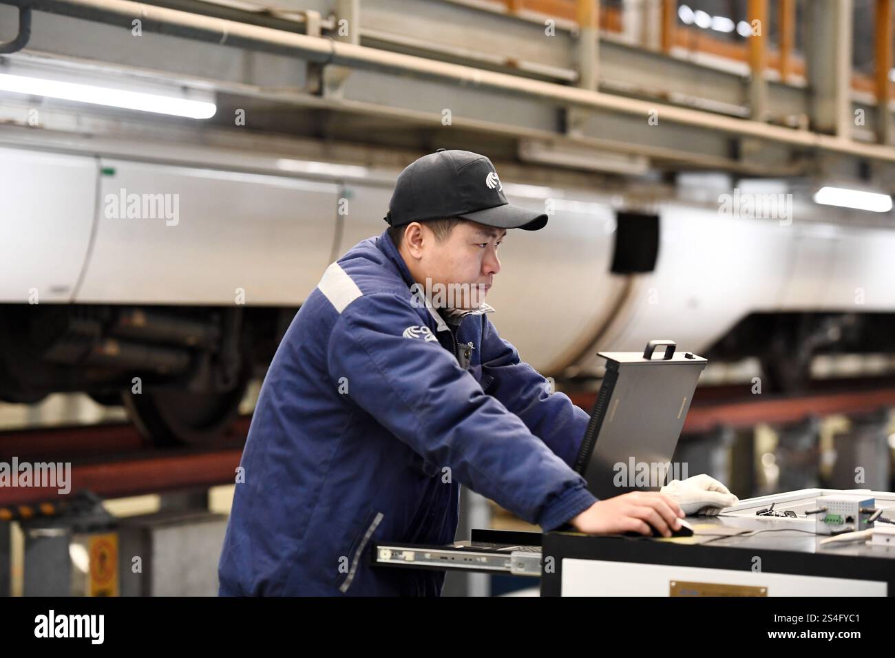 Service Emu A staff member inspects an EMU train at the inspection and repair ...