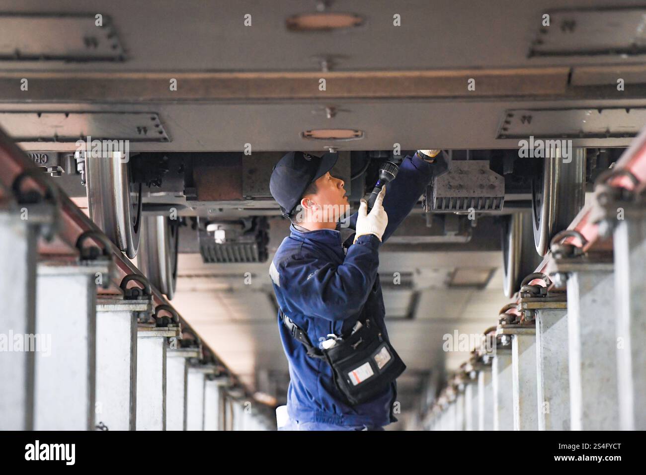 Service Emu A staff member inspects an EMU train at the inspection and repair ...