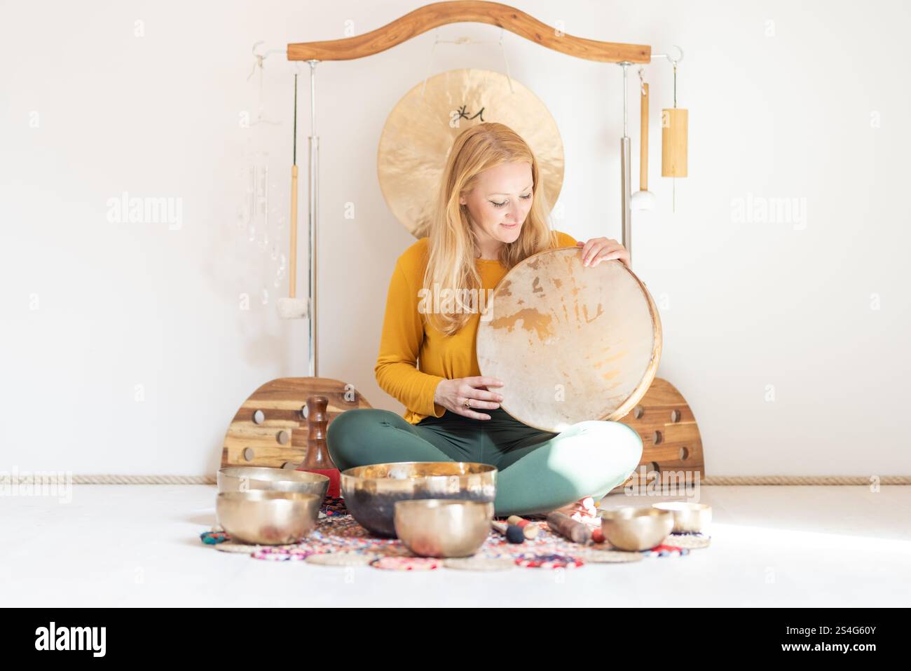 Young cheerful woman performing music therapy session with traditional ...