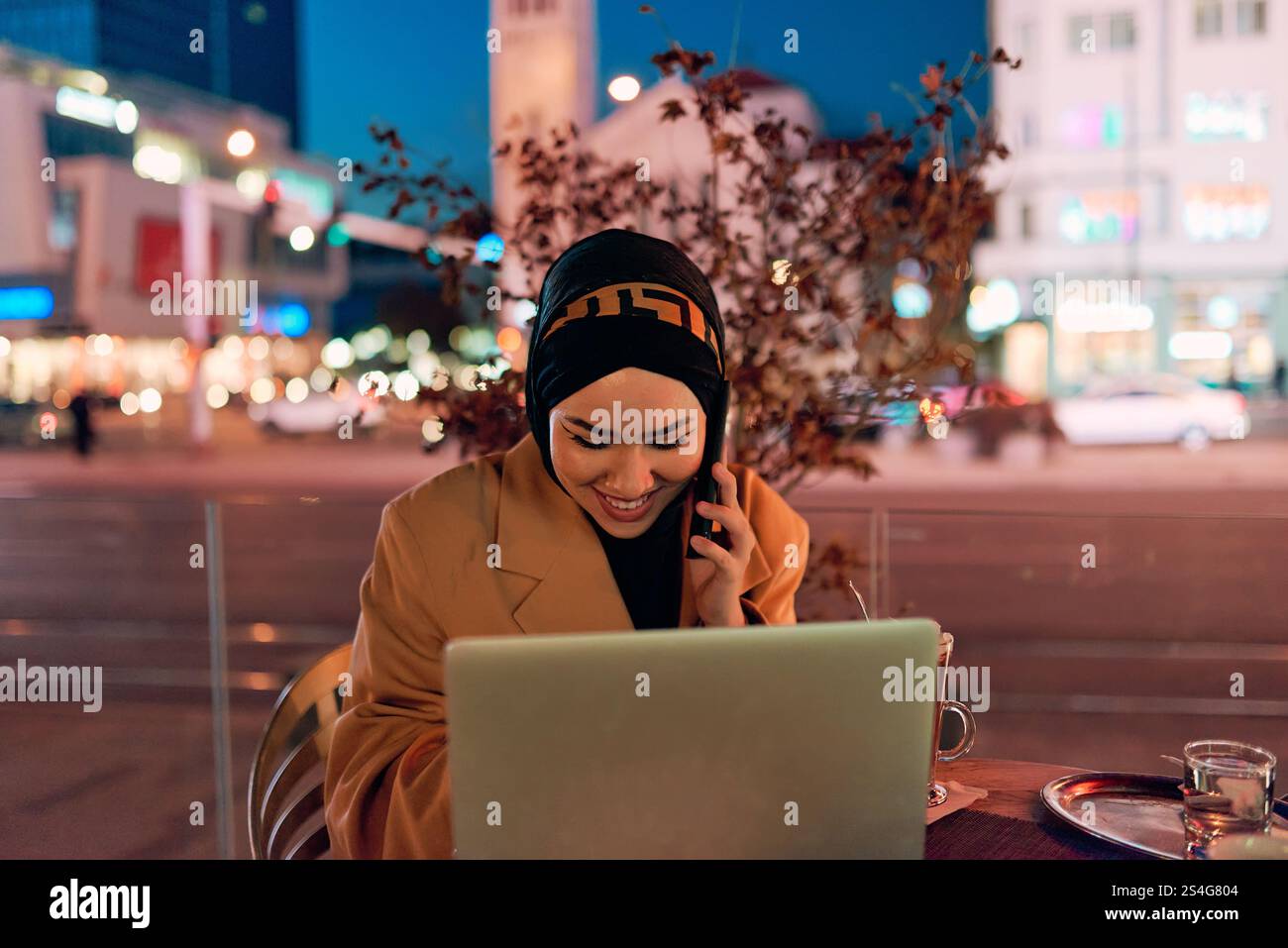A hijab woman using laptop and smartphone at a modern coffe in the ...