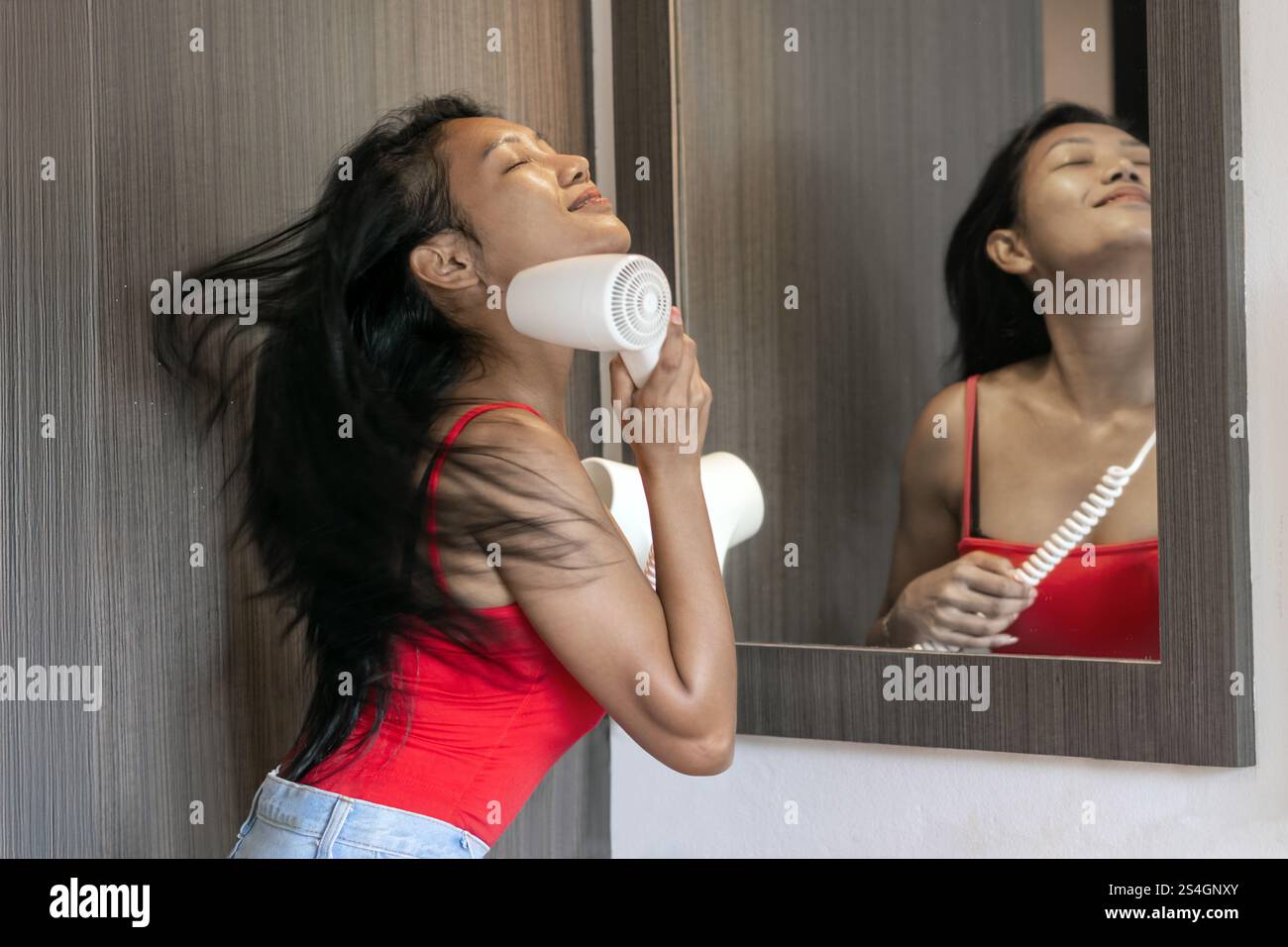 Smiling woman has enjoy from blow drying with flying hair Stock Photo