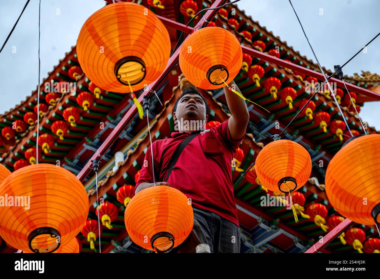 A worker installs the lantern decorations in Thean Hou Temple ahead of