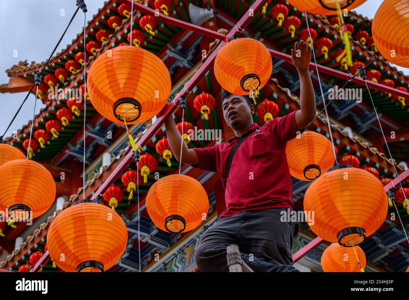 A worker installs the lantern decorations in Thean Hou Temple ahead of