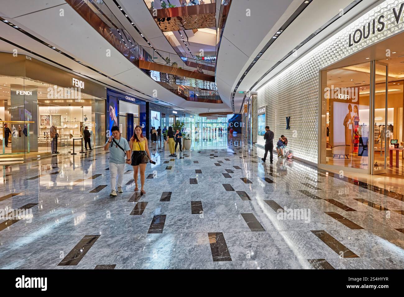 People walk inside the Exchange TRX, an upscale shopping mall in Kuala Lumpur, Malaysia. Stock Photo