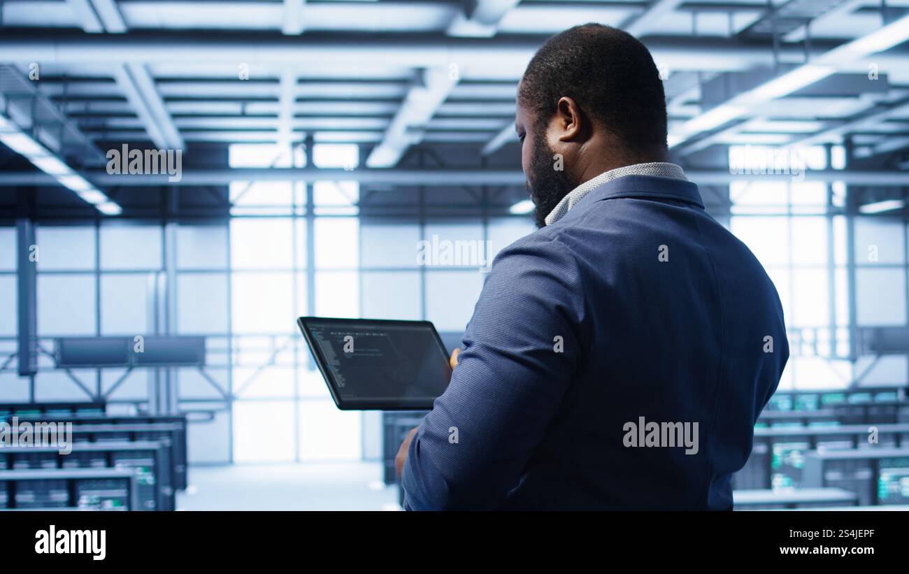 IT operator in server room workspace using tablet to patch network ...