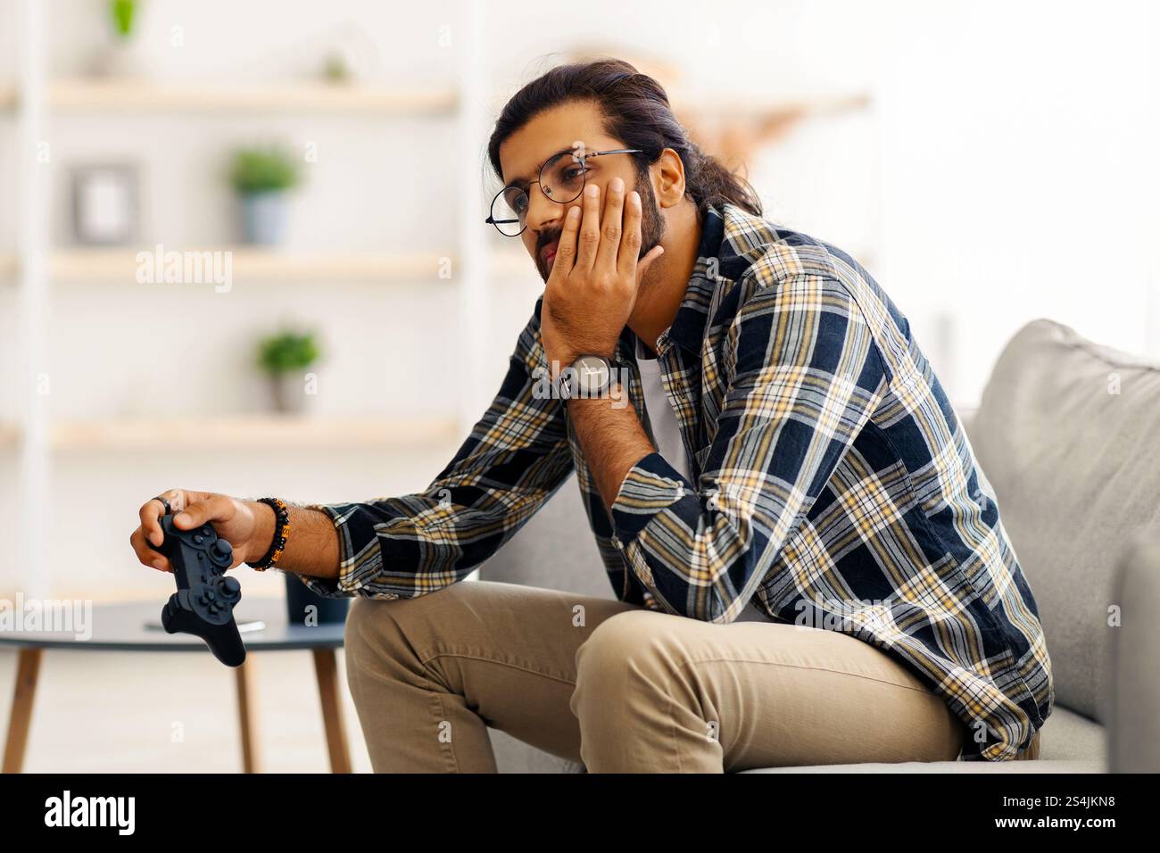 Upset middle-eastern guy got bored while playing video games Stock Photo