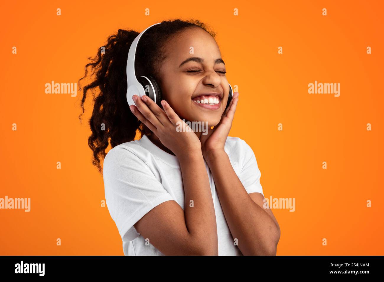 Smiling Young Black Girl Listening To Music In Headset Stock Photo - Alamy