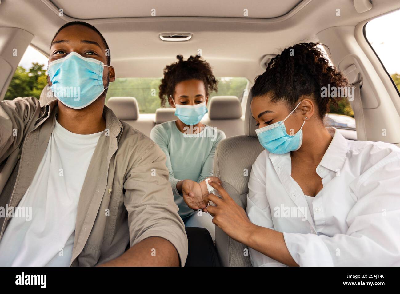 Black Family Using Sanitizer Wearing Face Masks Traveling By Car Stock ...