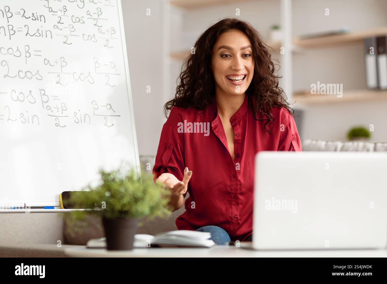 Smiling lady teacher explaining trigonometric functions to students online Stock Photo