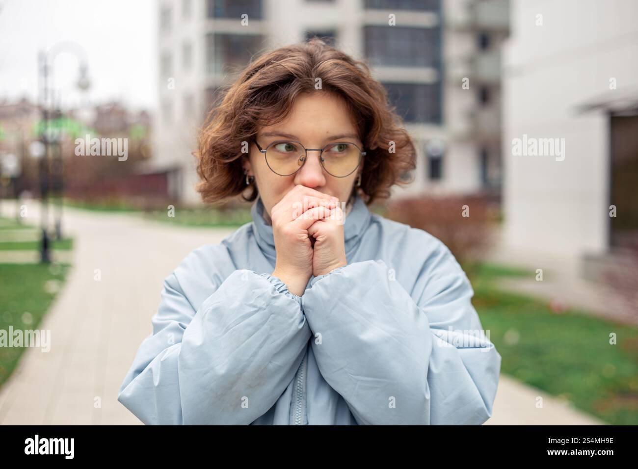 Freezing woman. A young beautiful frozen girl suffers from cold weather ...