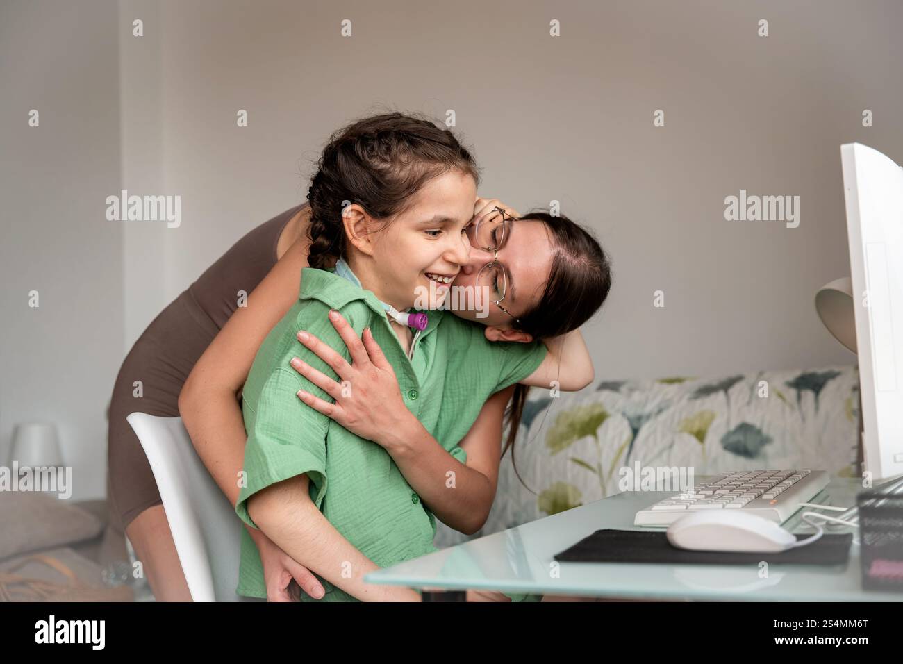 Young disabled girl with a tracheostomy, being embraced and kissed by ...