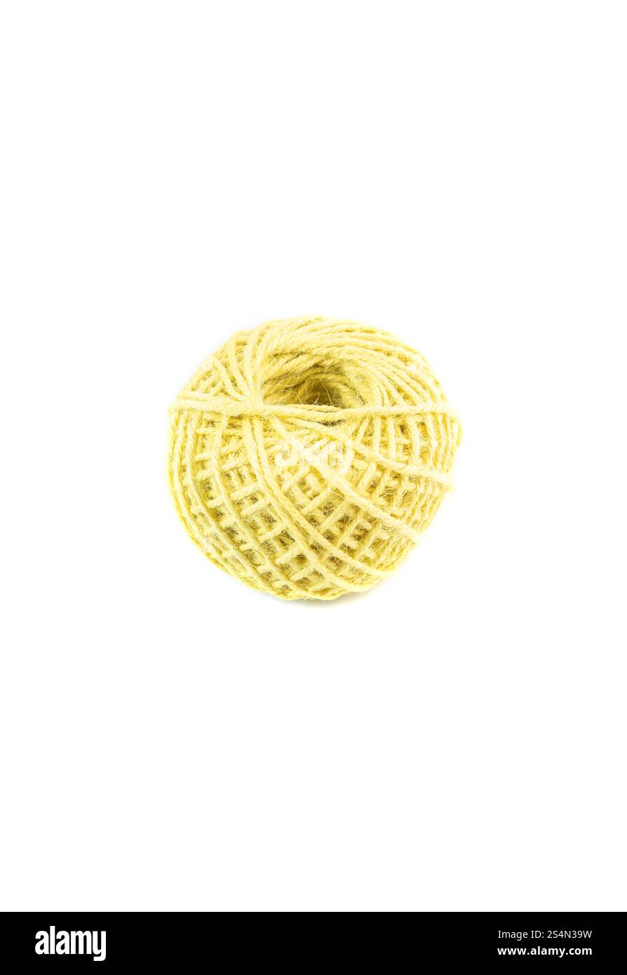 A roll of yellow jute twine placed on a white background, ideal for crafting, packaging, and DIY projects. Perfect for online stores or product catalo Stock Photo
