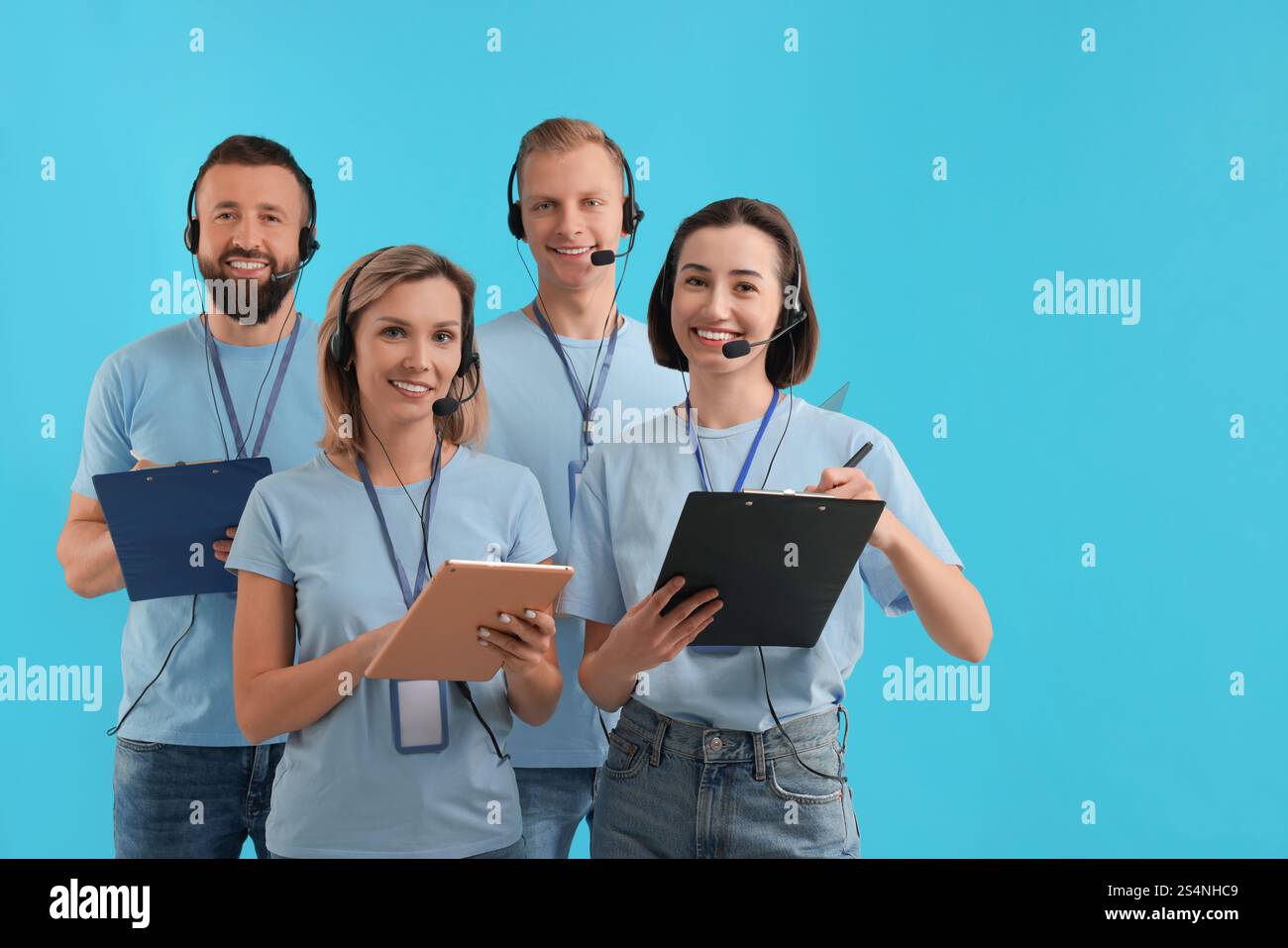 Technical support call center. Team of friendly operators on light blue ...
