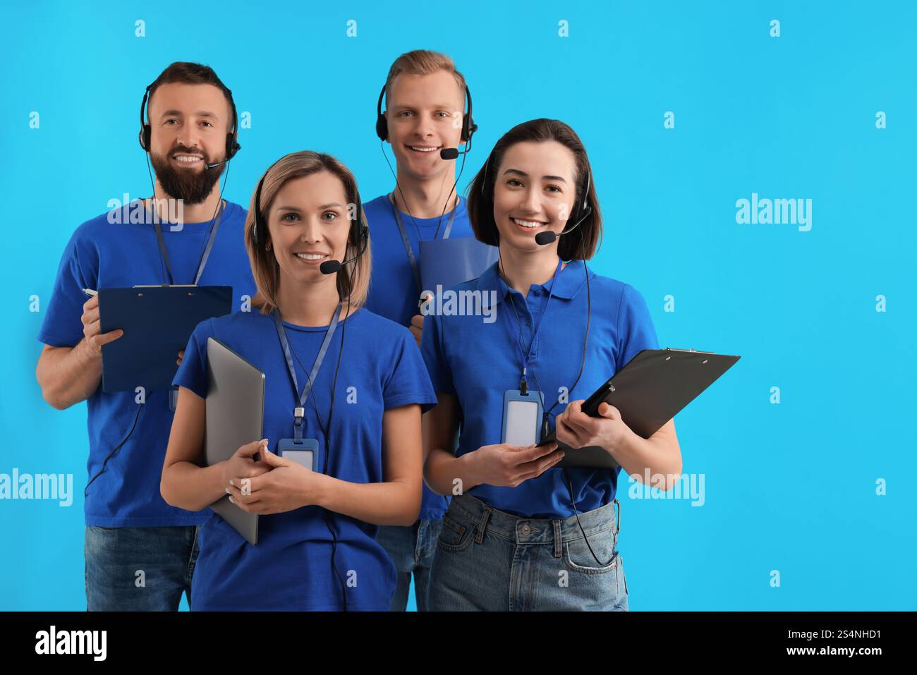 Technical support call center. Team of friendly operators on light blue ...