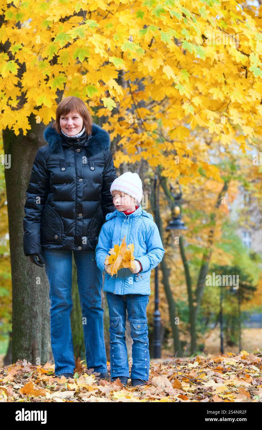 Mother with small daughter in golden autumn city park Stock Photo - Alamy