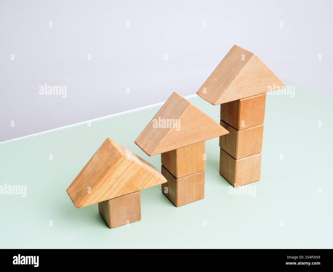 Three wooden arrowhead built by cube blocks as bar graph chart steps on