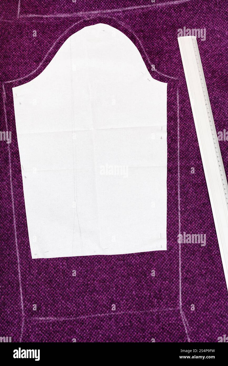 fitter ruler and pattern cut of woollen cloth on cutting table Stock Photo