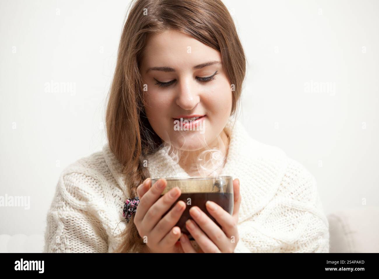 Portrait of brunette woman looking at vaporing tea cup Stock Photo