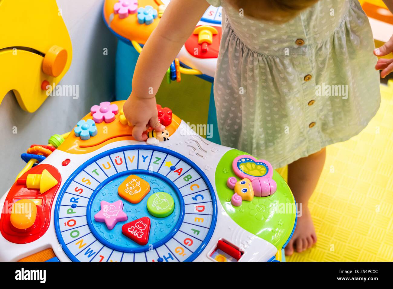 Toddler exploring shapes and colors on activity table. Concept of ...