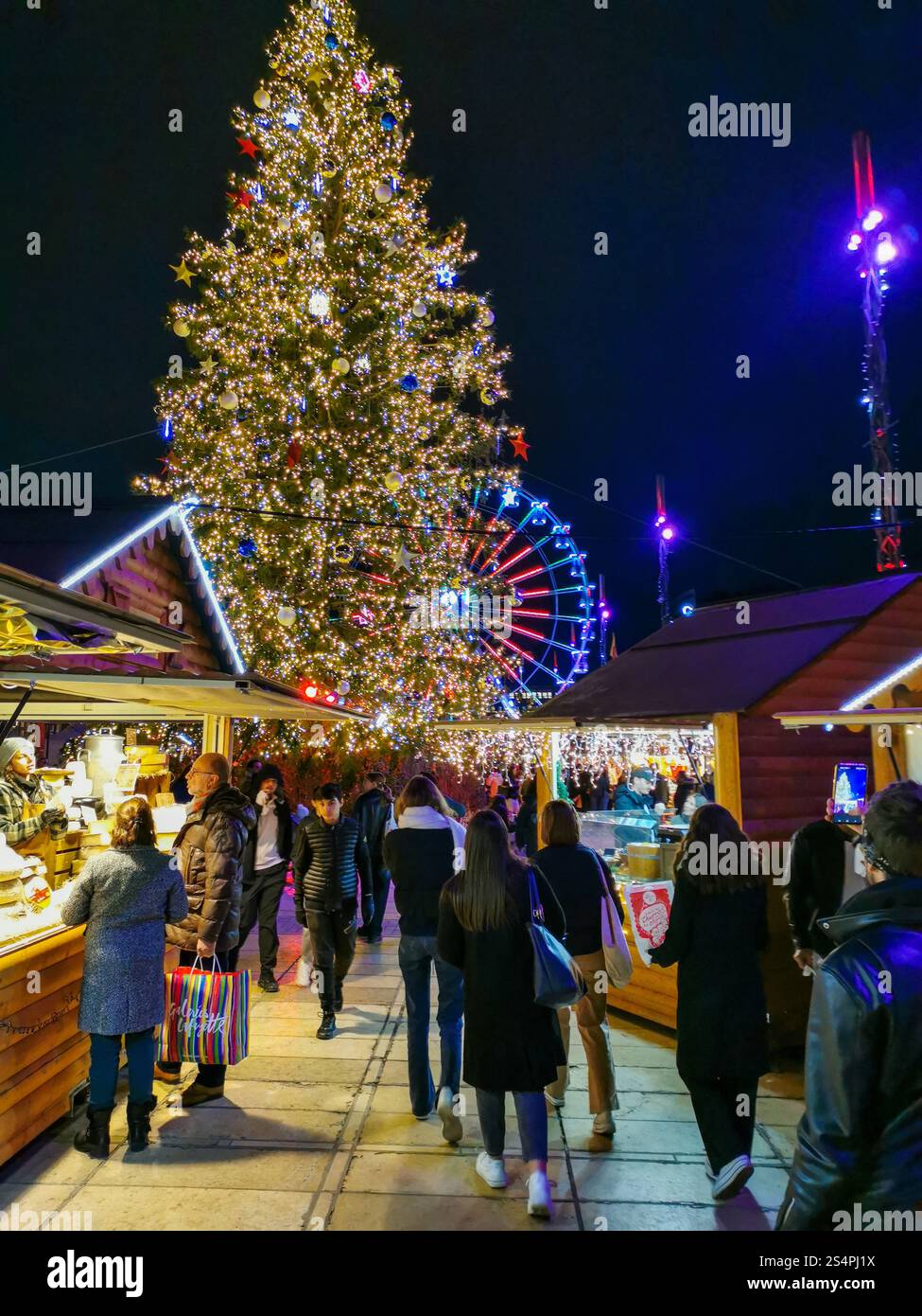 Visitors stroll through the vibrant Christmas market on Place de Jaude in Clermont-Ferrand, admiring the decorations and enjoying festive treats. - Smartphone Captured Stock Image