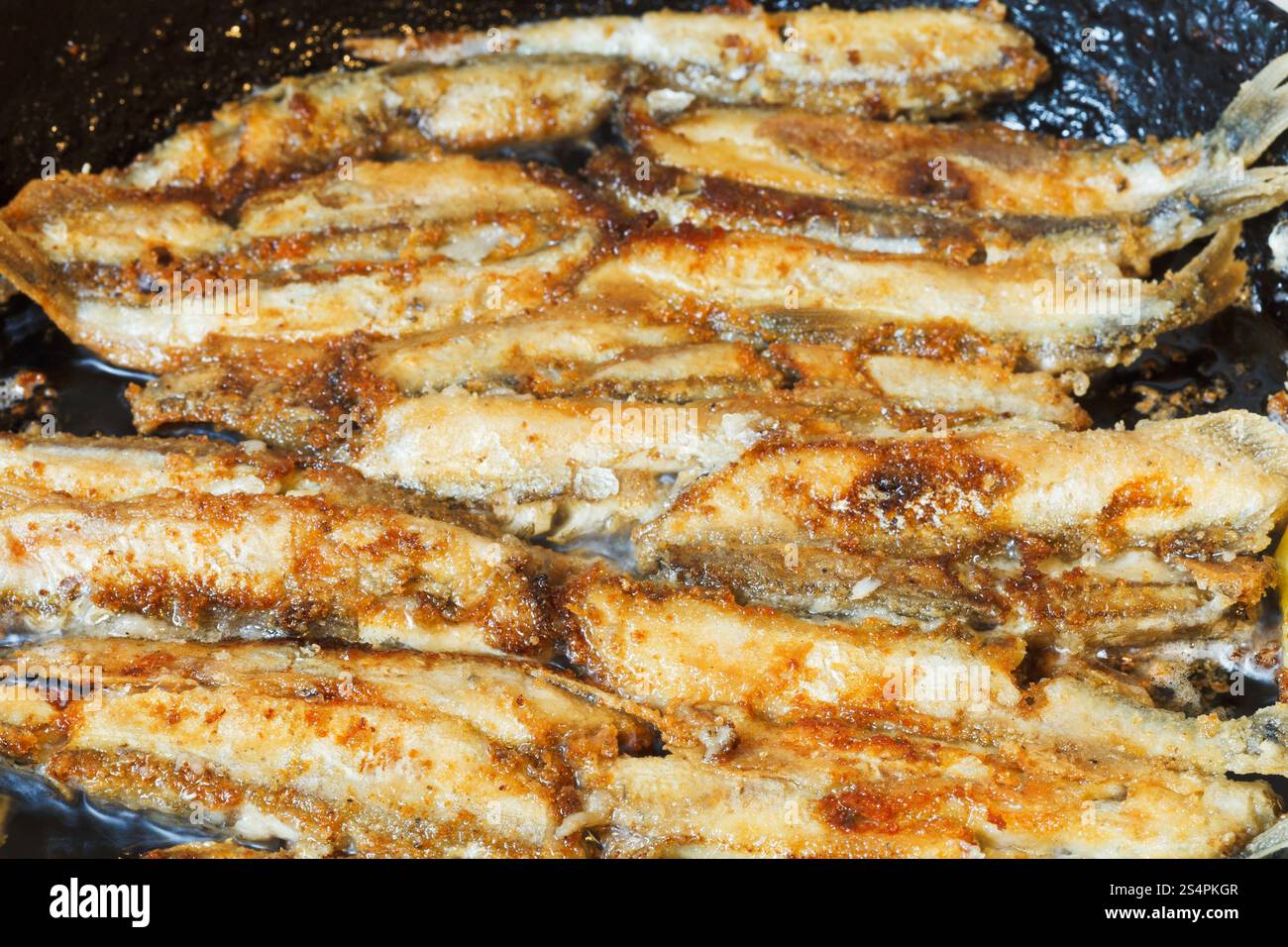 fried fish capelin on frypan close up Stock Photo - Alamy