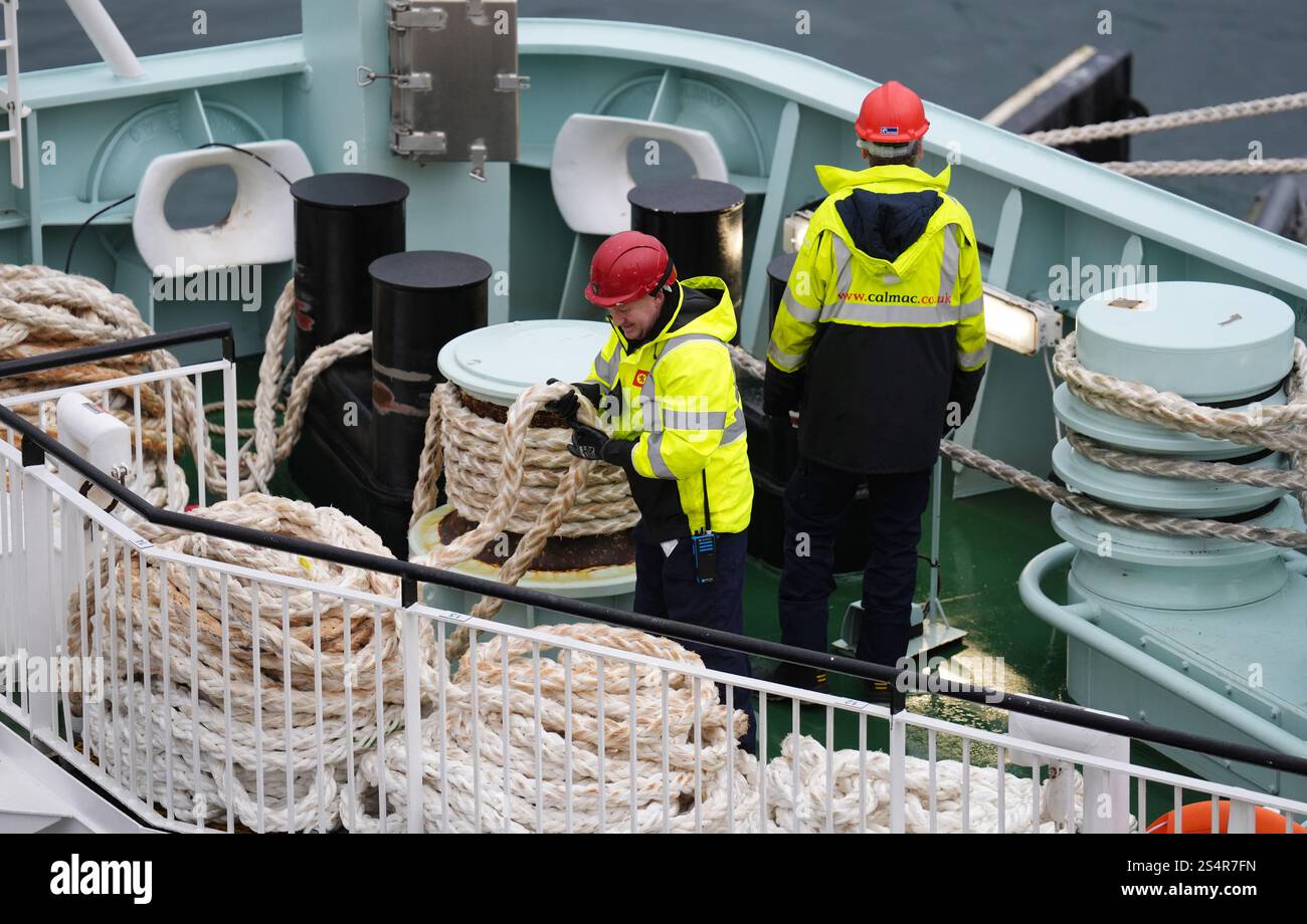 Workers pull ropes on board The Glen Sannox ferry ahead of departing