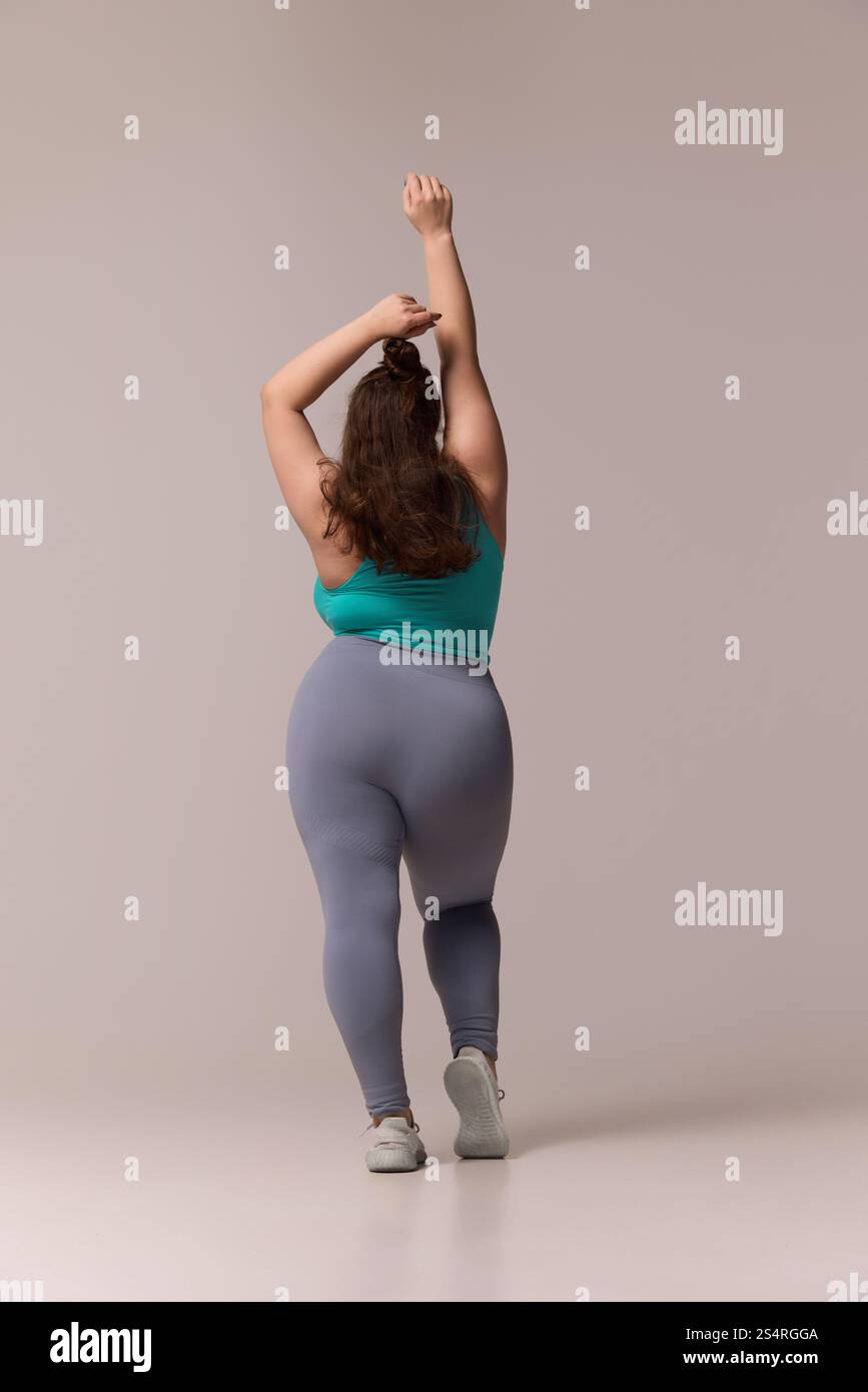 Full length, rear view photo of plus size woman dressed athleticwear ...