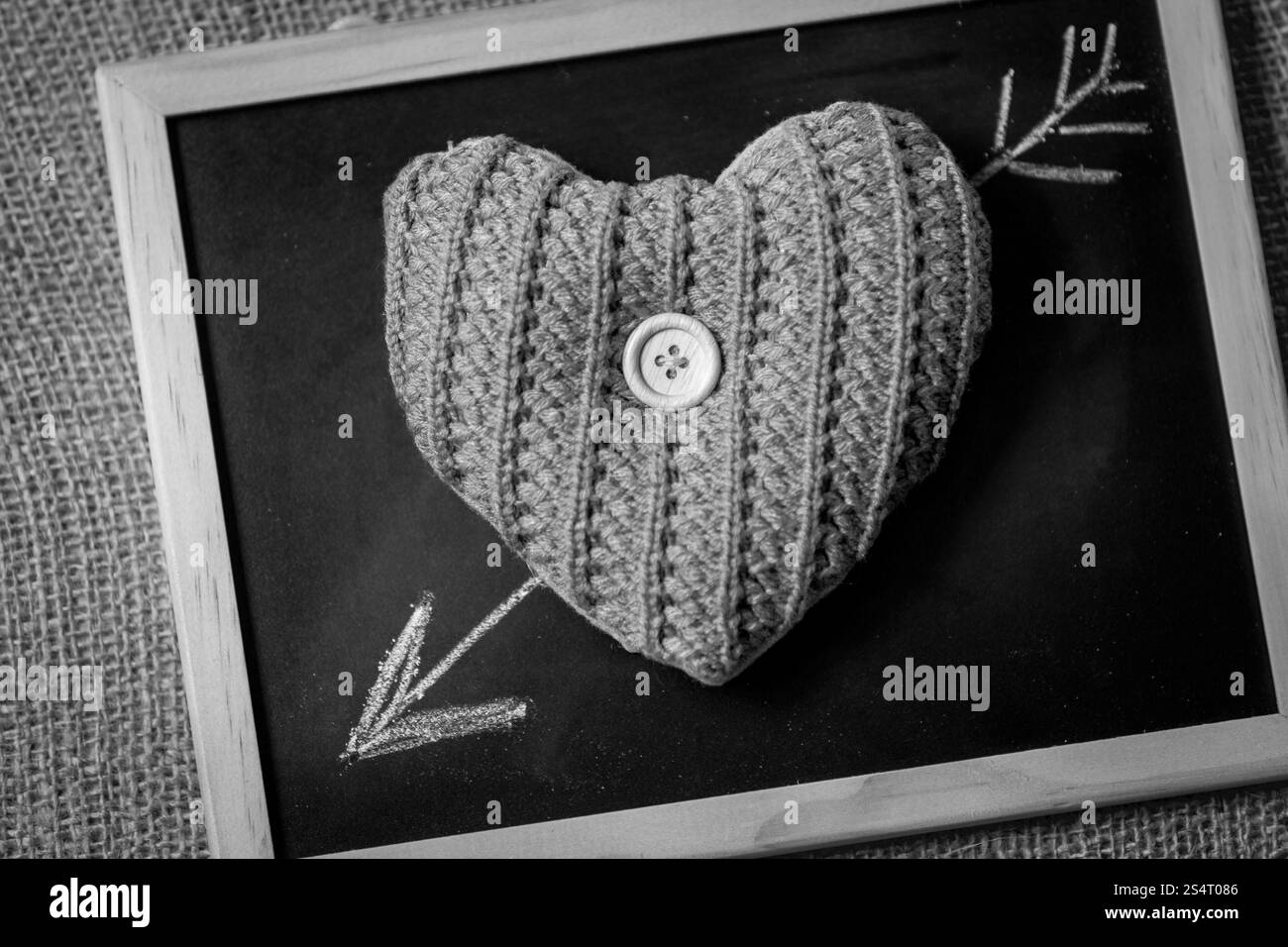 Black and white photo of drawn by chalk arrow going through knitted ...
