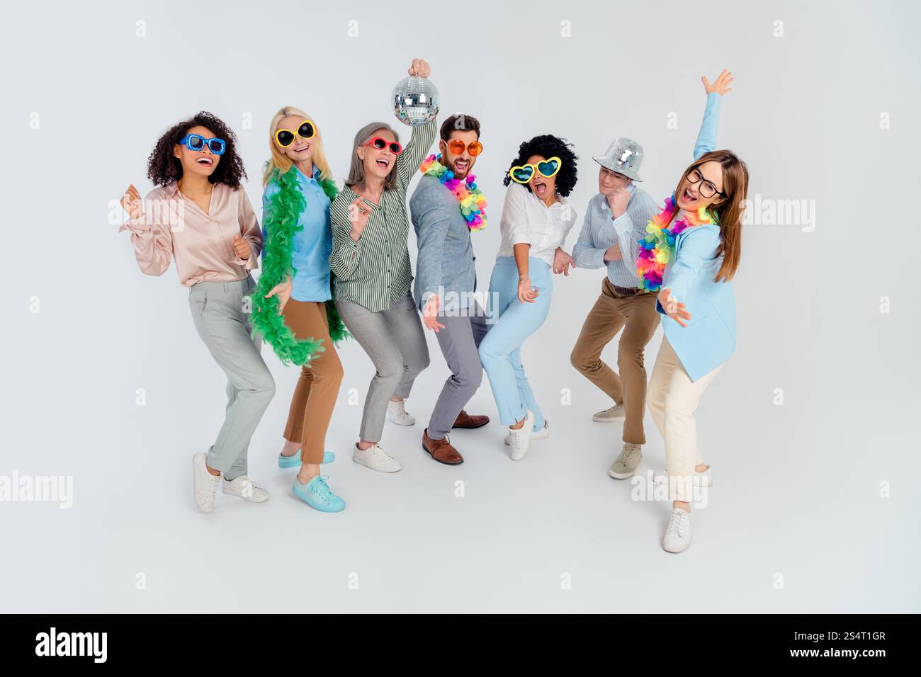 Group of diverse colleagues celebrating teamwork with fun props over a ...